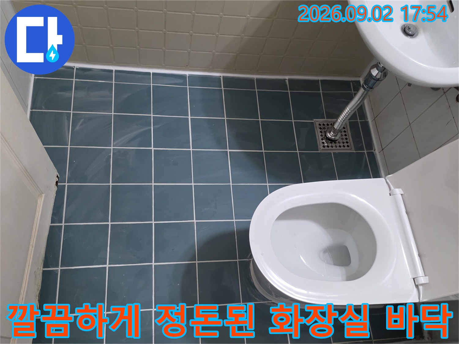 욕실 내부 전경-푸른색 타일과 하얀 변기가 설치된 모습