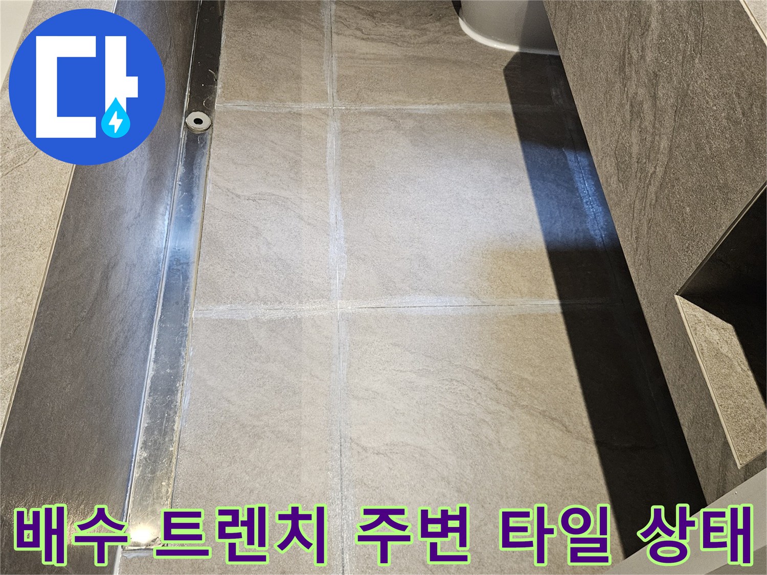길게 설치된 배수 트렌치와 그 주변 대리석 타일의 연결 부위 모습입니다.
