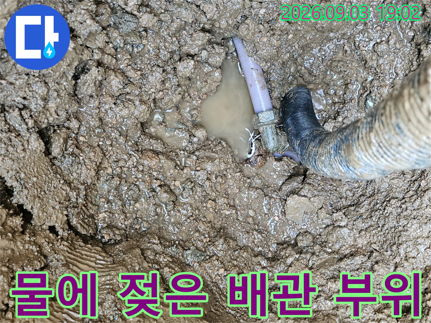 누수가 발생하여 주변 토사가 젖어 있는 수도 배관