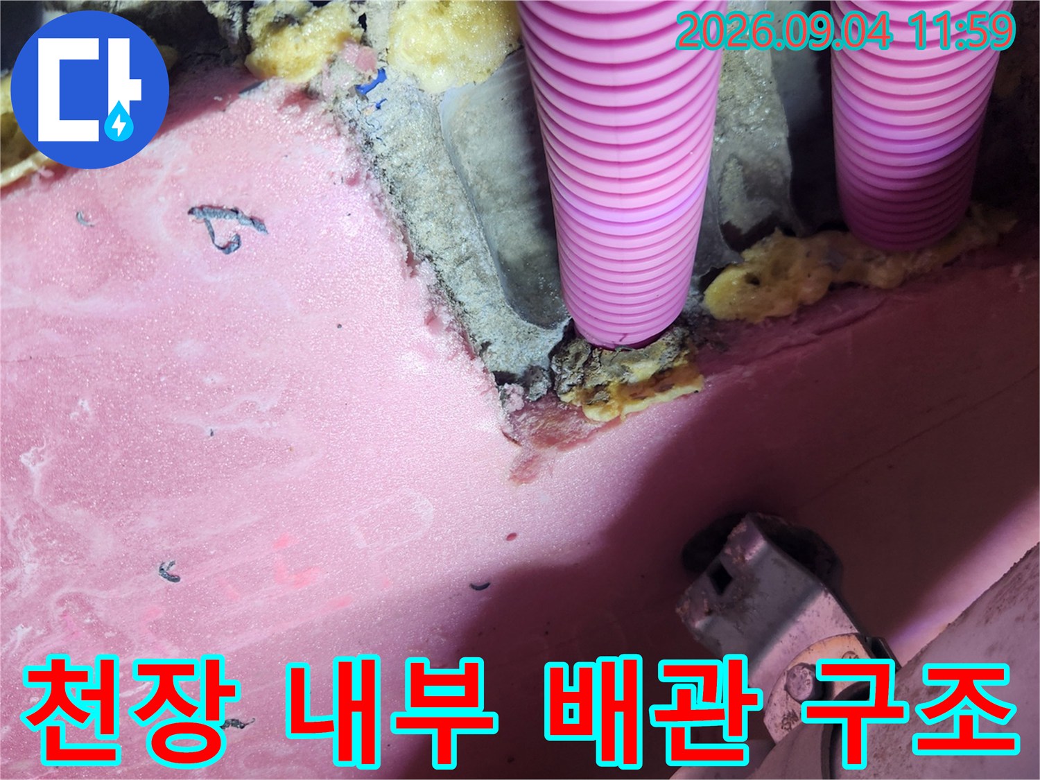 분홍색 이중배관과 노란 단열재가 포함된 천장 내부 모습
