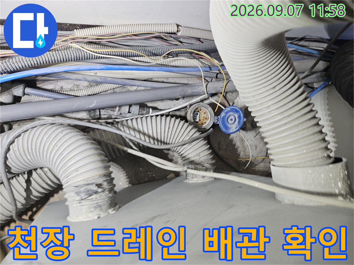 천장 내부의 에어컨 주름 배관과 전기 콘센트 주변을 점검하는 장면입니다.