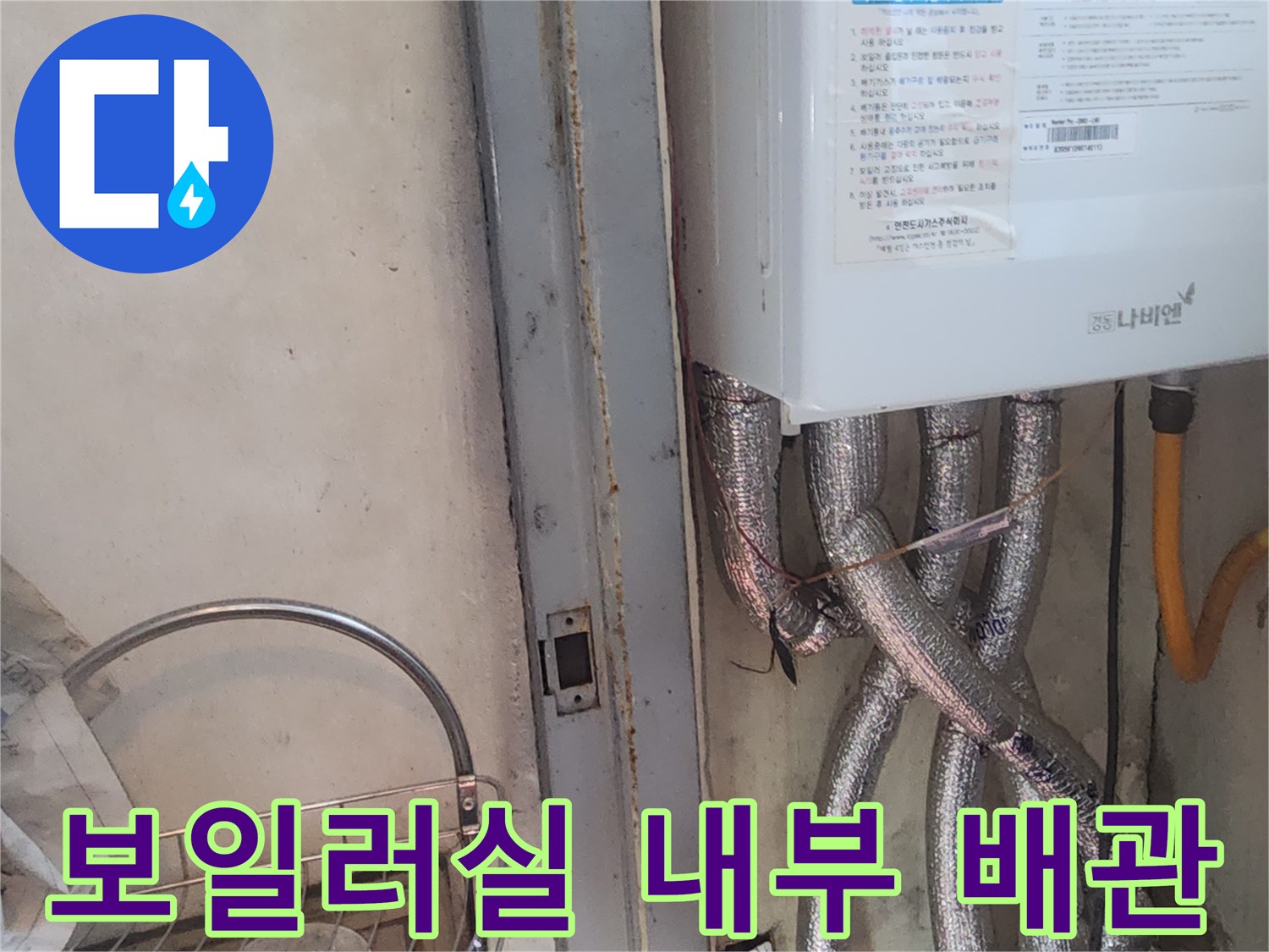 보일러 하단에 연결된 은박 보온재 마감 배관의 근접 사진입니다.
