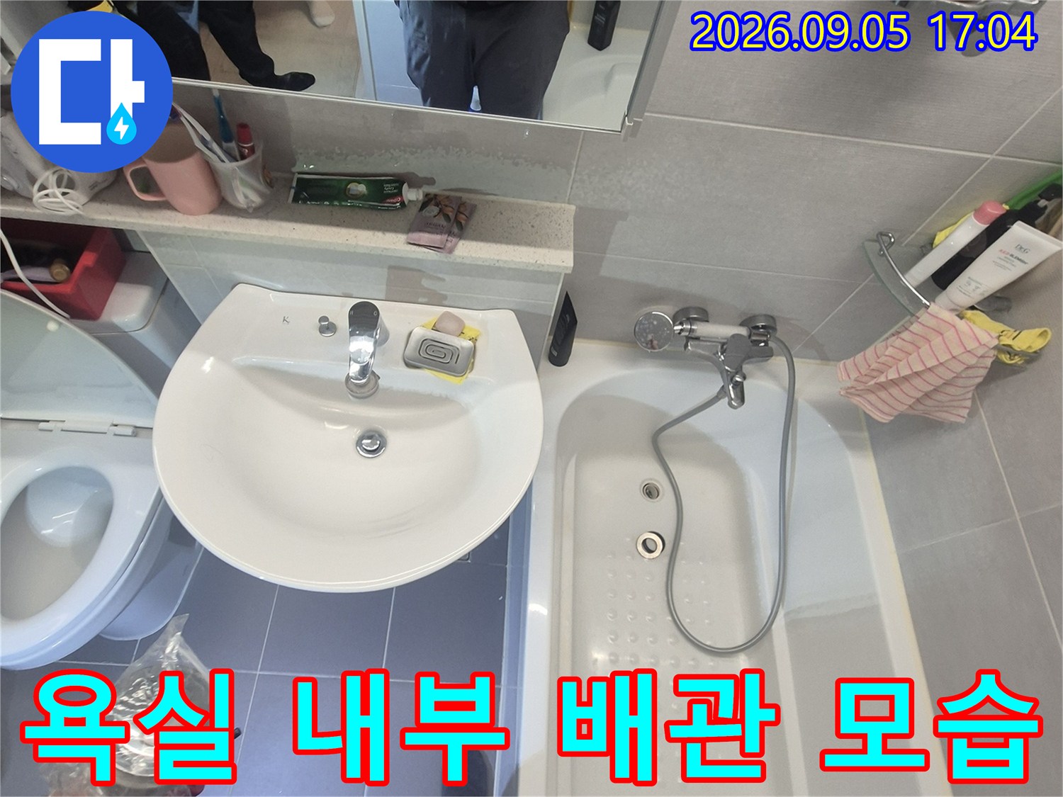 욕조 수전과 세면대가 배치된 화장실 전경