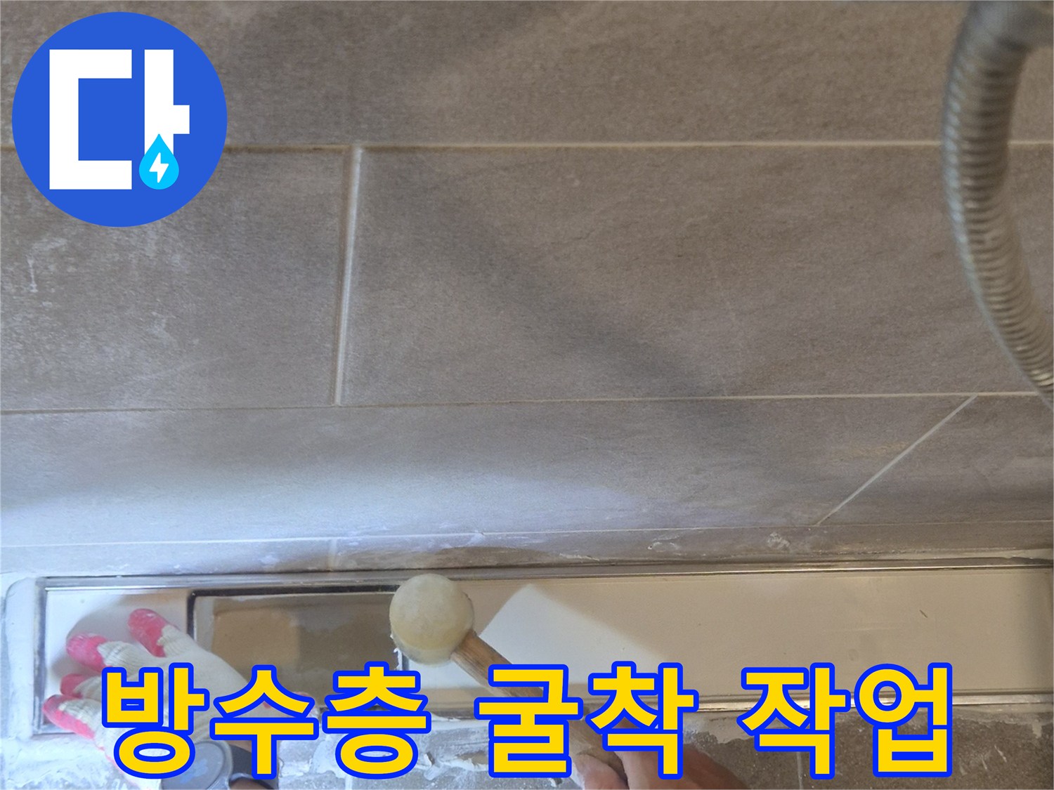 망치를 이용해 욕실 유가 주변 타일을 분리하며 누수 경로를 탐색함