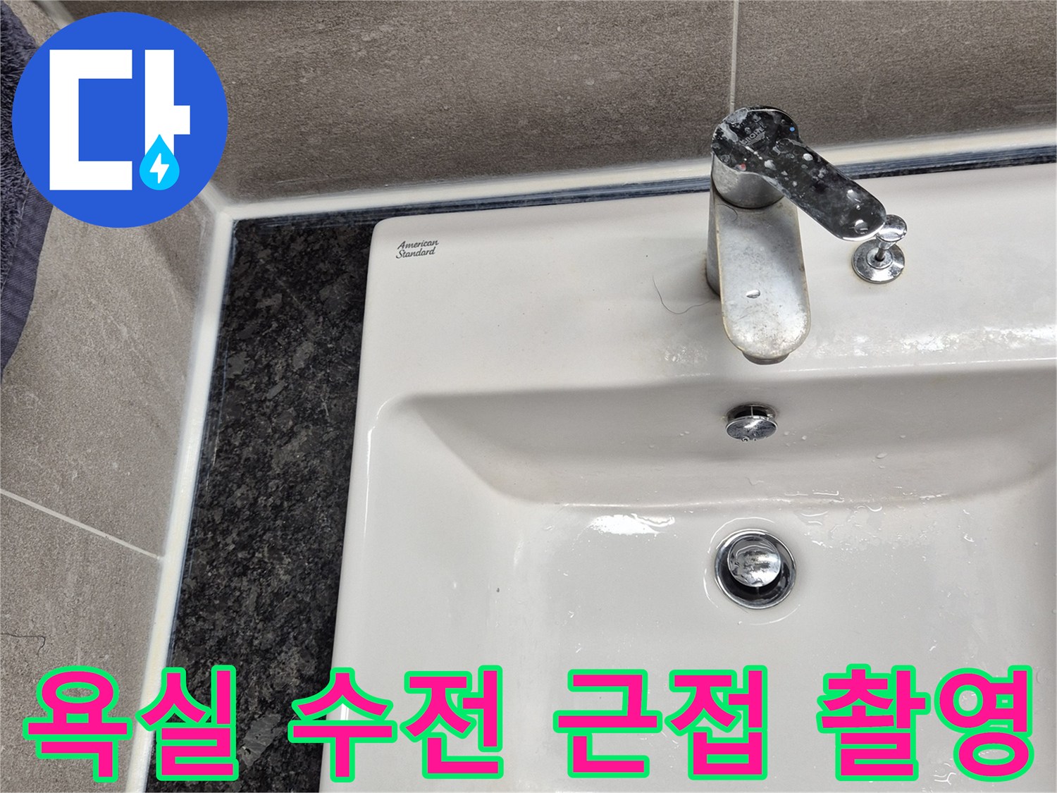세면대 옆에 위치한 수도 밸브와 타일 벽면의 모습입니다.