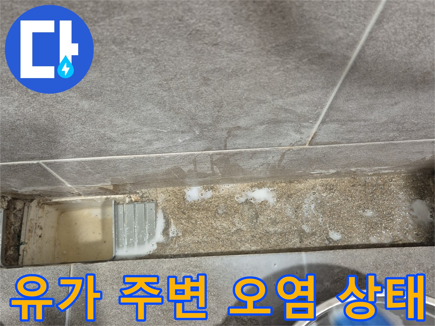 욕실 유가 틈새의 변색된 타일과 습기를 촬영한 사진입니다.