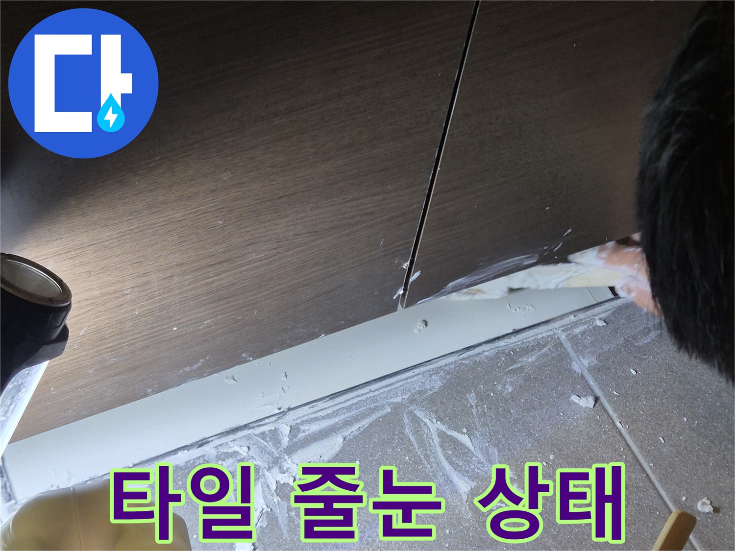 욕실 타일 사이의 시멘트와 배수구 주변 보수 작업 중