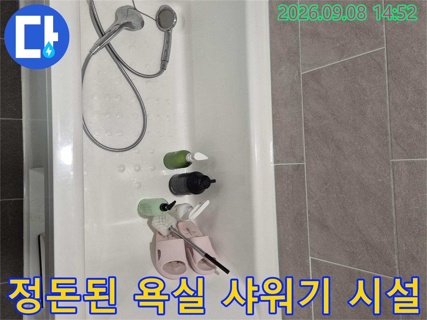 욕조 내부에 놓인 세면 용품과 샤워기 헤드입니다.