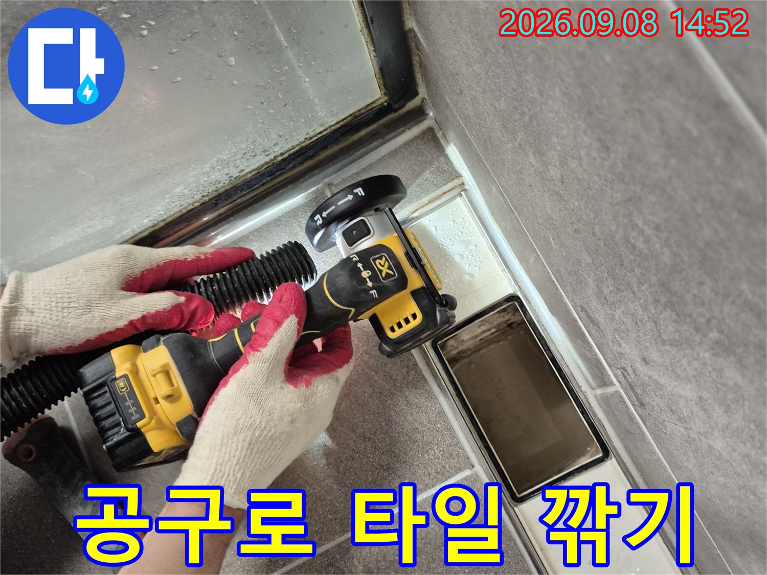 작업자가 전동 드릴을 활용하여 타일을 제거하는 모습