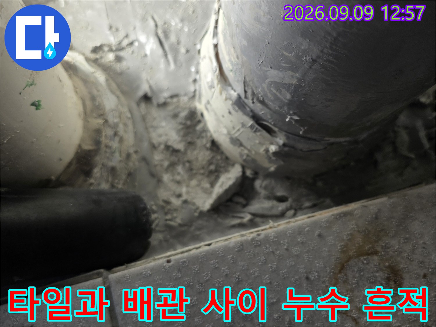 타일 틈새로 스며든 물자국과 노후된 배관 연결부