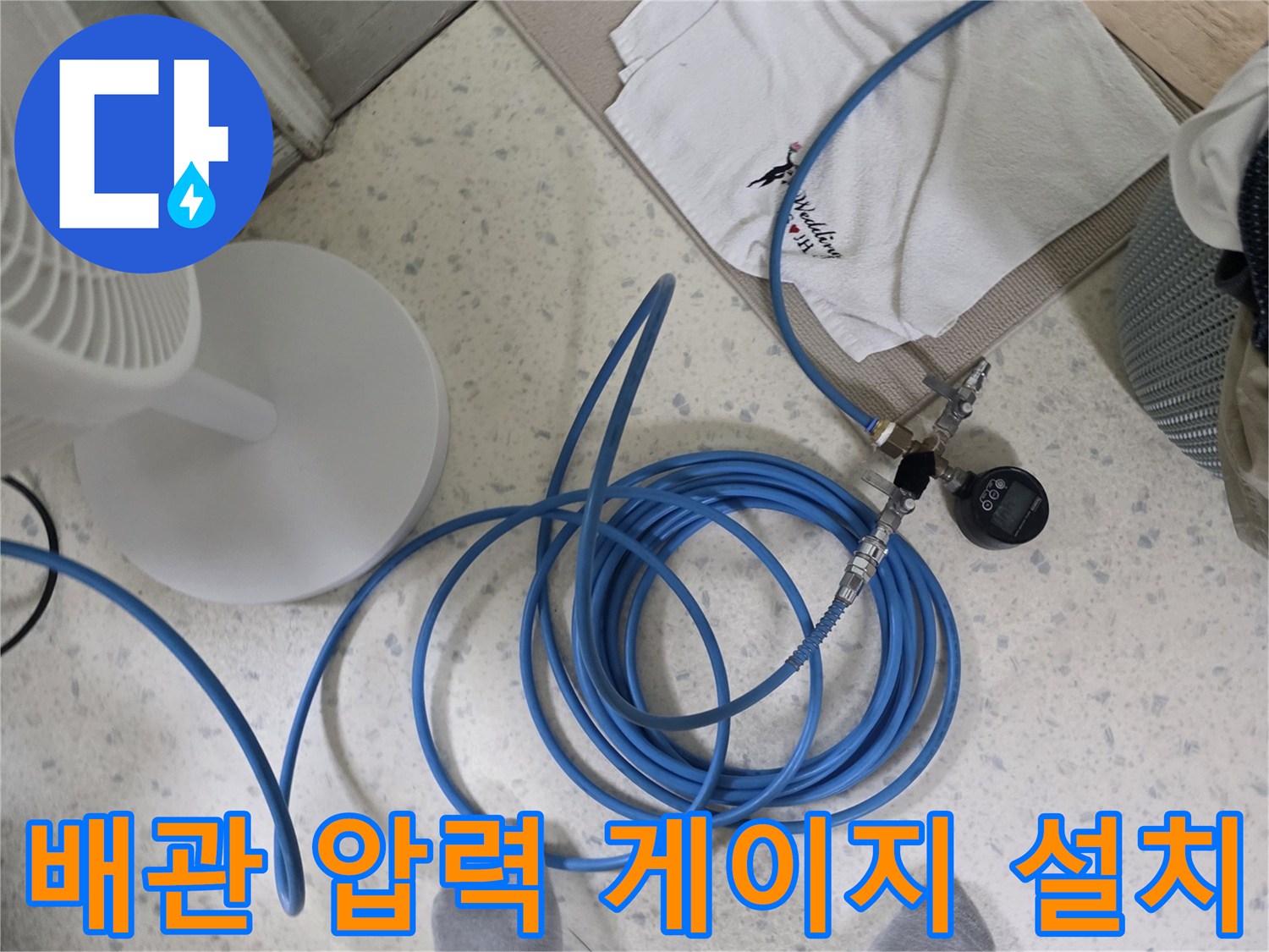 파란색 고압 호스와 연결된 배관용 압력 측정 장치