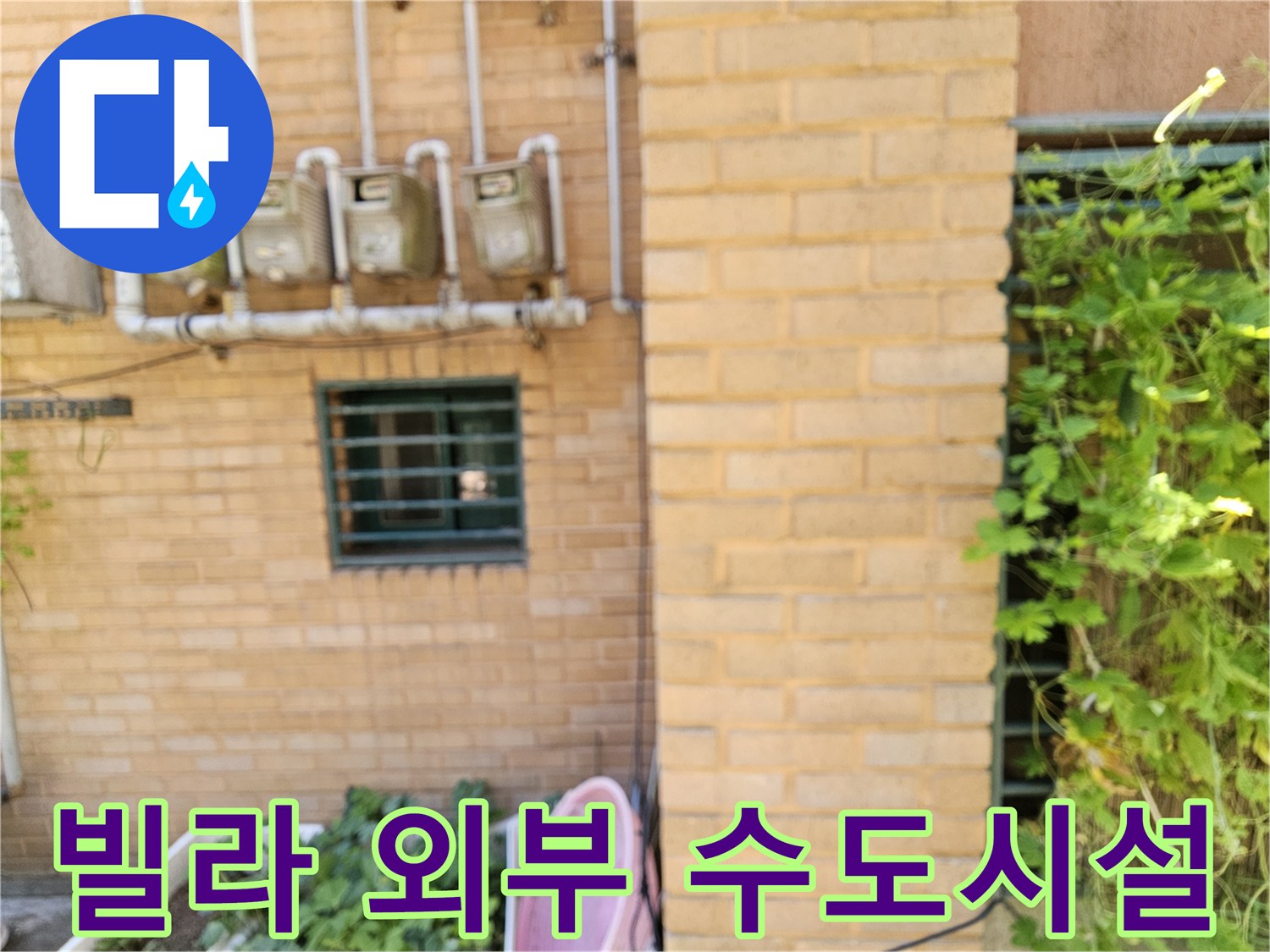 벽돌 외벽에 설치된 다수의 수도 계측 장치와 배관들입니다.