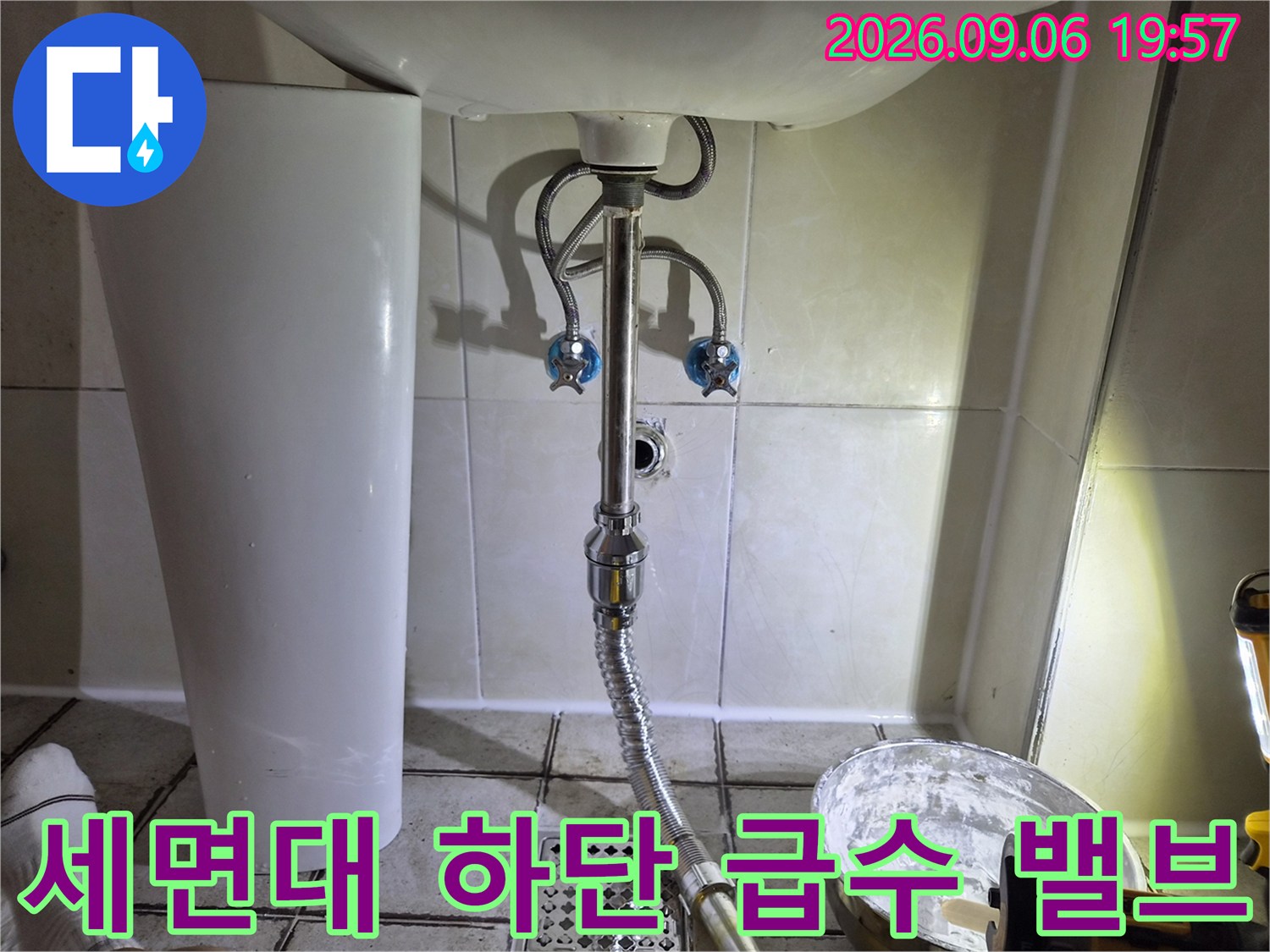세면대 아래쪽 배관 연결 부위와 벽면 수전의 클로즈업