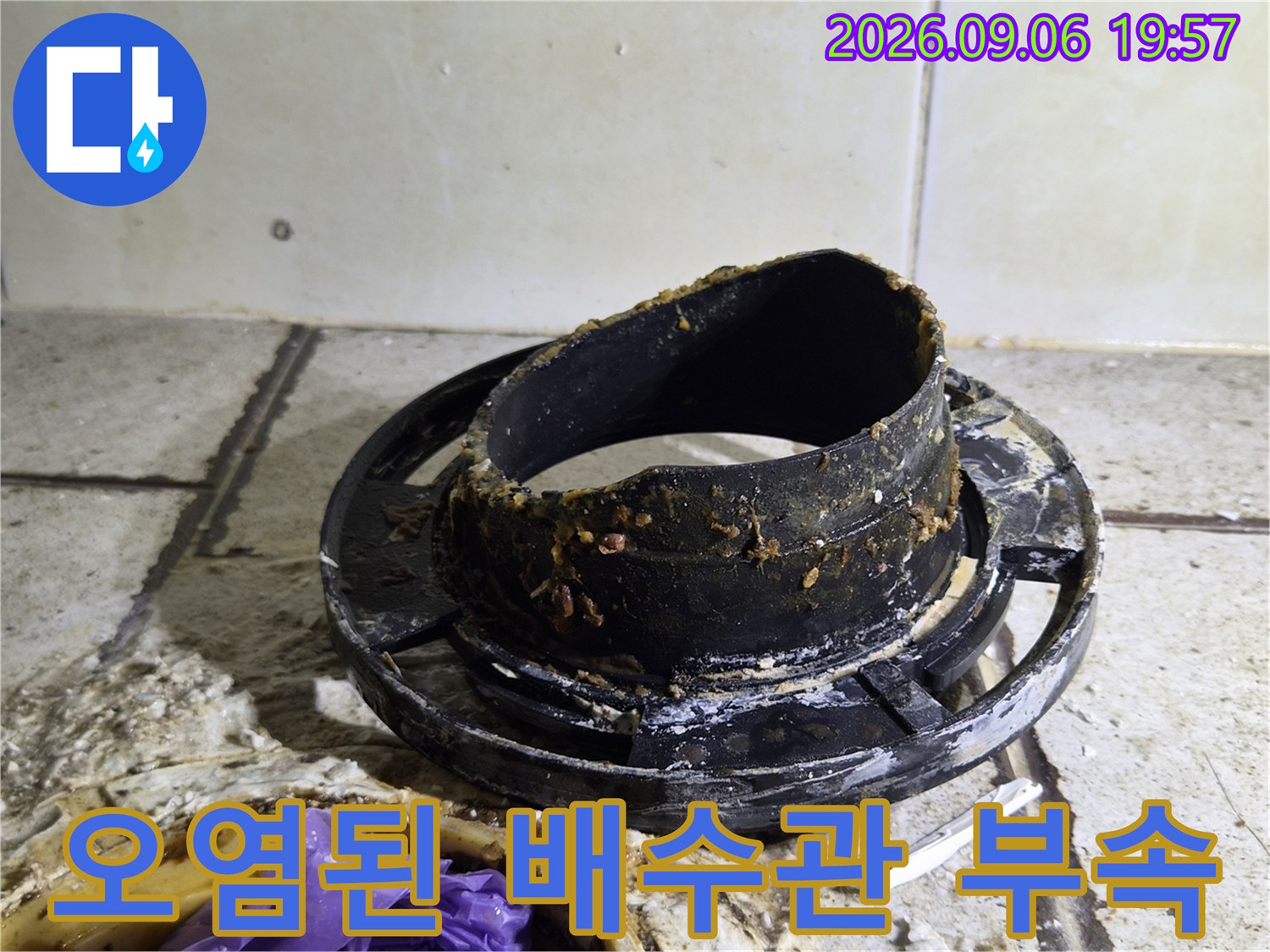 이물질로 오염된 검은색 배수관 연결 부속 모습입니다.