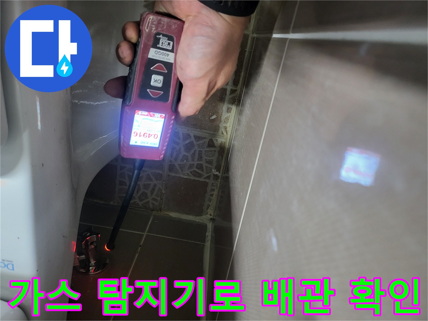 변기 뒷쪽 벽면 타일 부근에서-누수 반응을 찾기 위해 탐지기를 운용하고 있습니다.