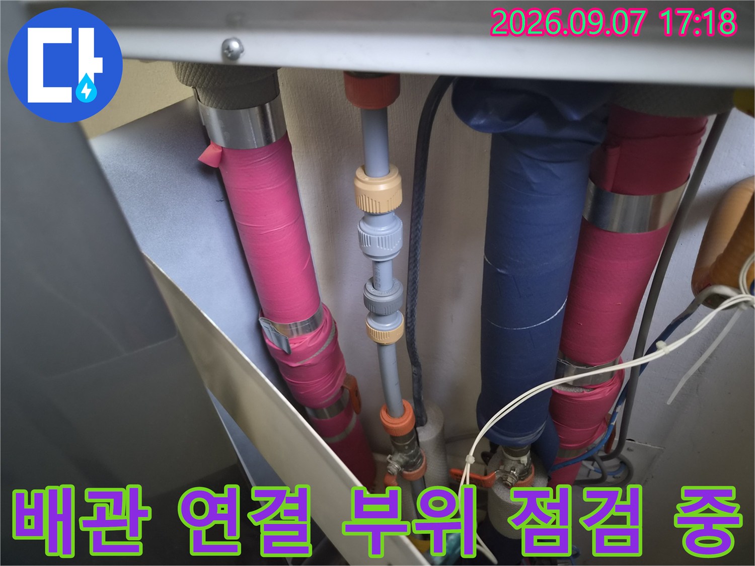 분홍색과 파란색-배관의 밸브 및 연결 지점을 정밀하게 확인하는 과정