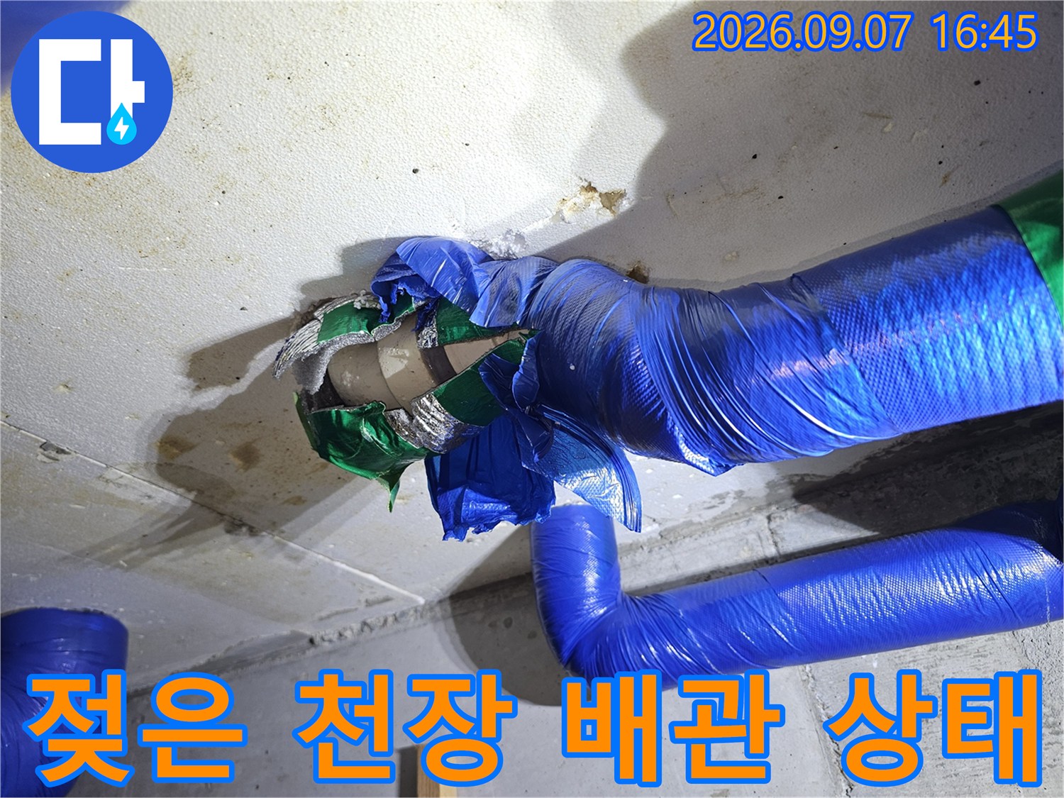 물기가 스며든 천장 콘크리트와 파란색 보온재가 감싸진 배관 연결부