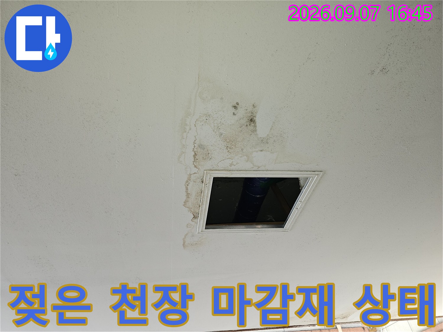 물에 젖어 변색된 필로티 주차장 천장 마감재와 점검구