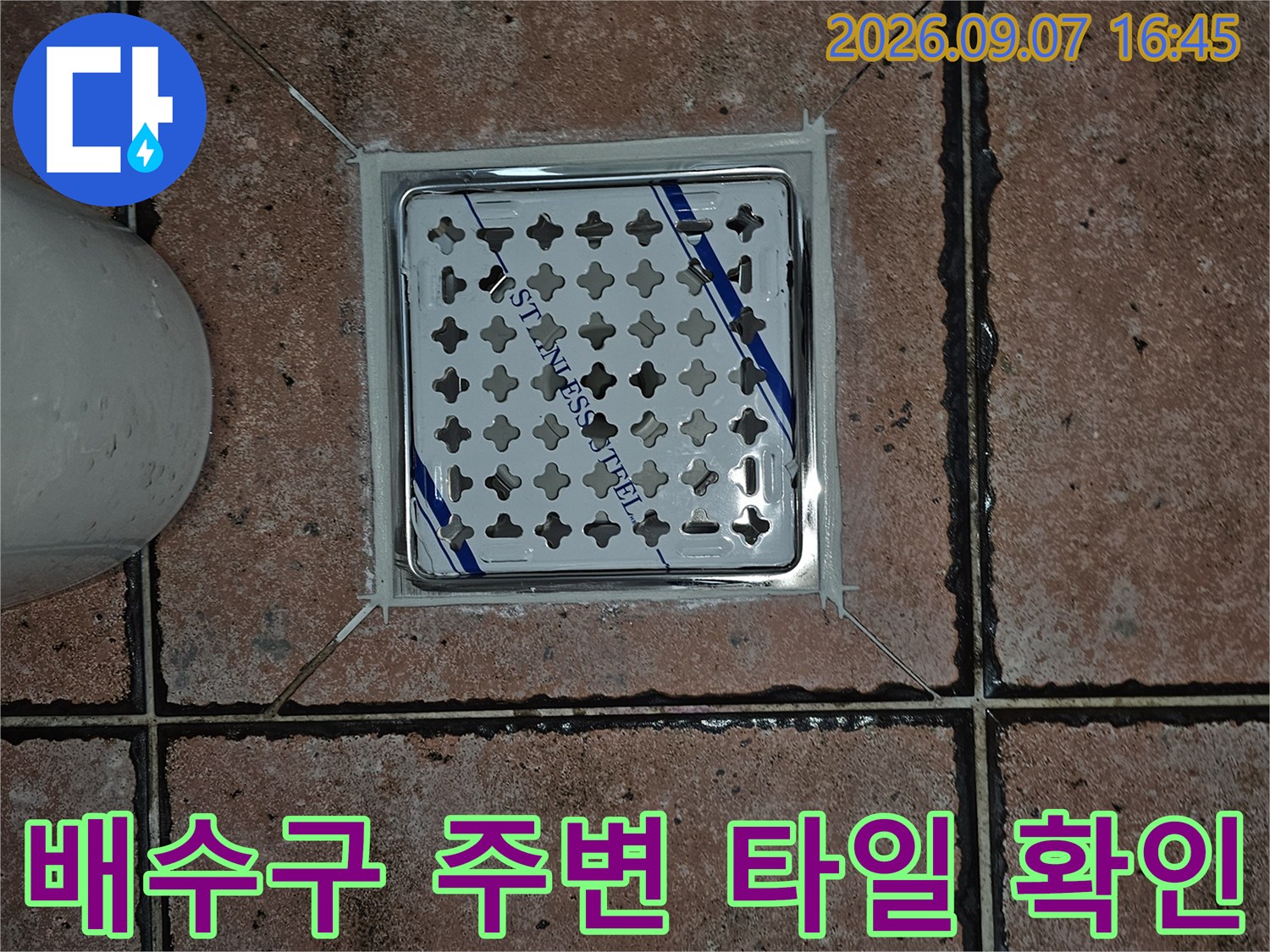 스테인리스 유가 덮개와 주변 타일 사이의 경계 부분을 촬영한 사진입니다.