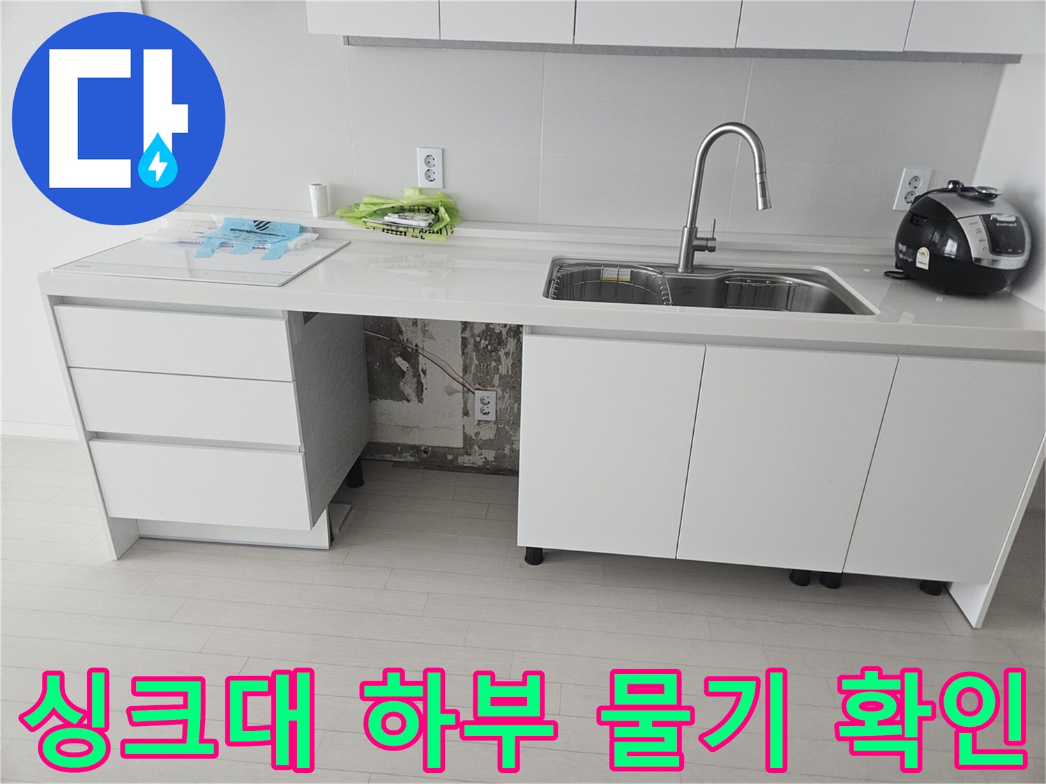 싱크대 밑 공간 - 누수로 인해 젖어 있는 배관 주변
