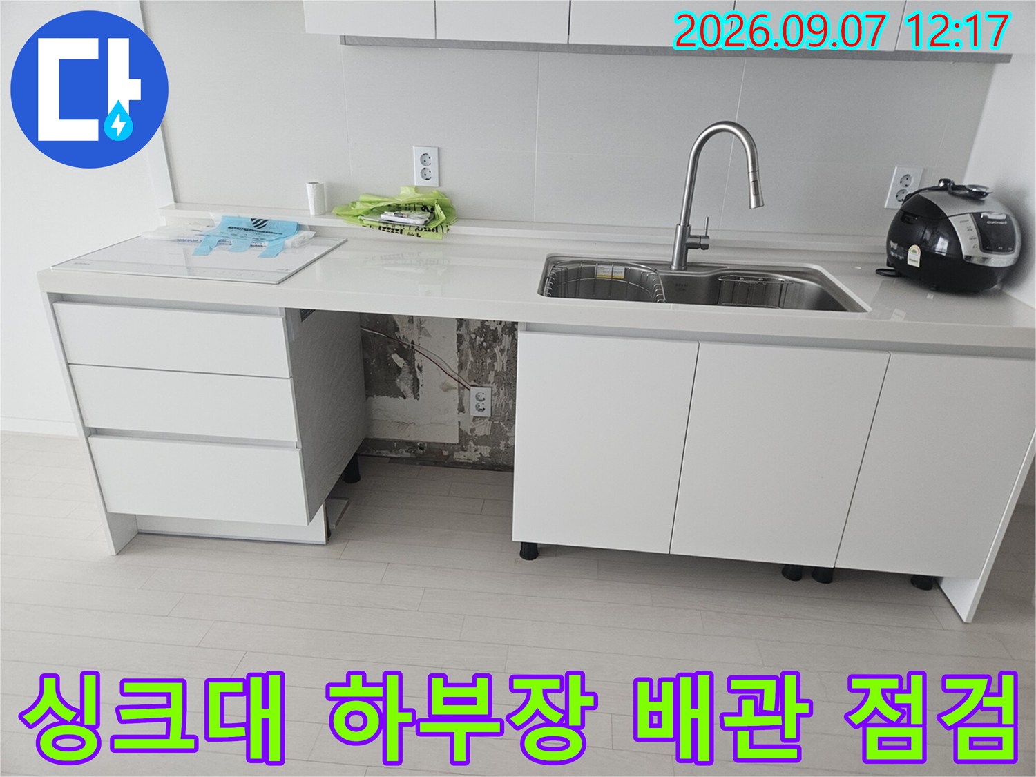 싱크대 아래쪽 정수기 호스 연결 부위의 누수 지점 확인 장면