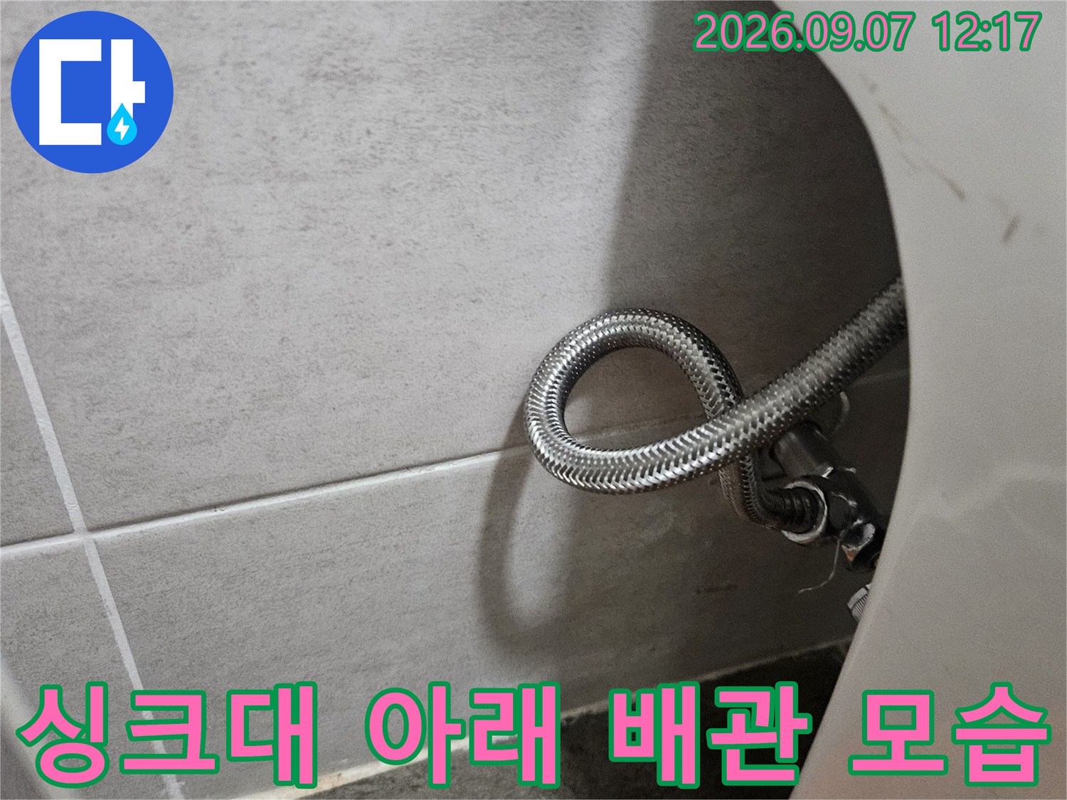 싱크대 하부장 아래쪽의 굽어있는 스테인리스 호스 연결 부위