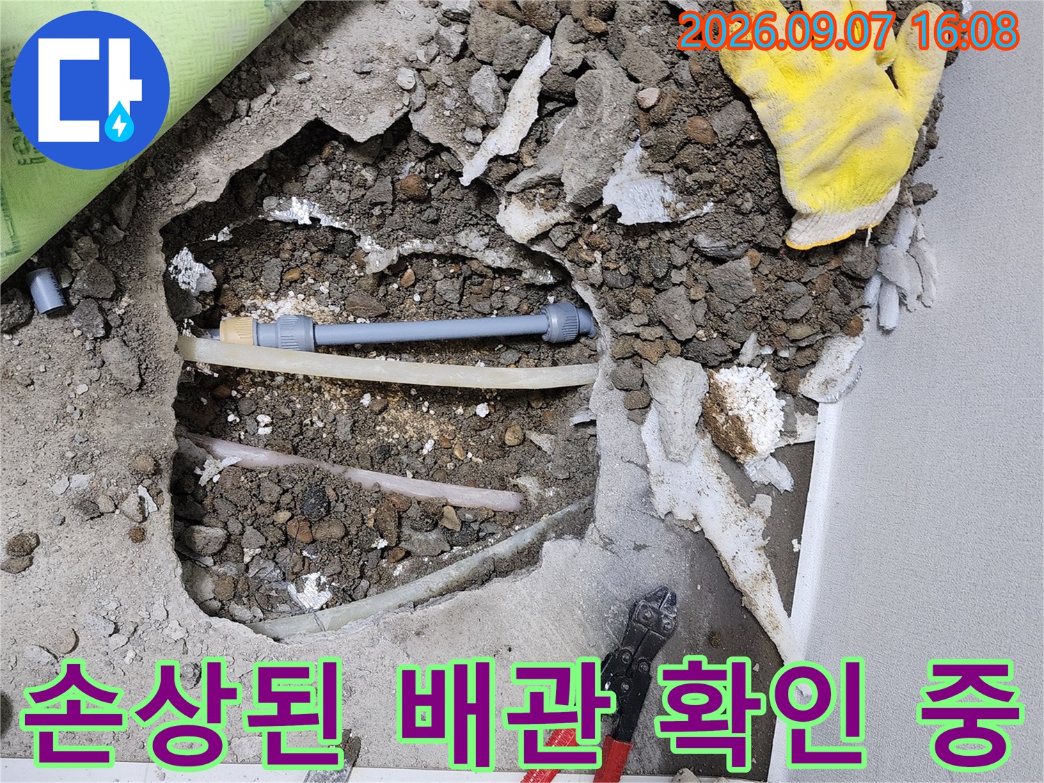 싱크대 앞 바닥을 파헤쳐서 드러난 수도 배관과 작업 장비입니다.