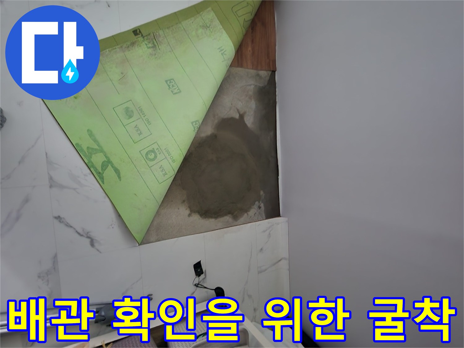 싱크대 주변 타일을 제거하여 배관 노출을 시도하는 장면입니다.