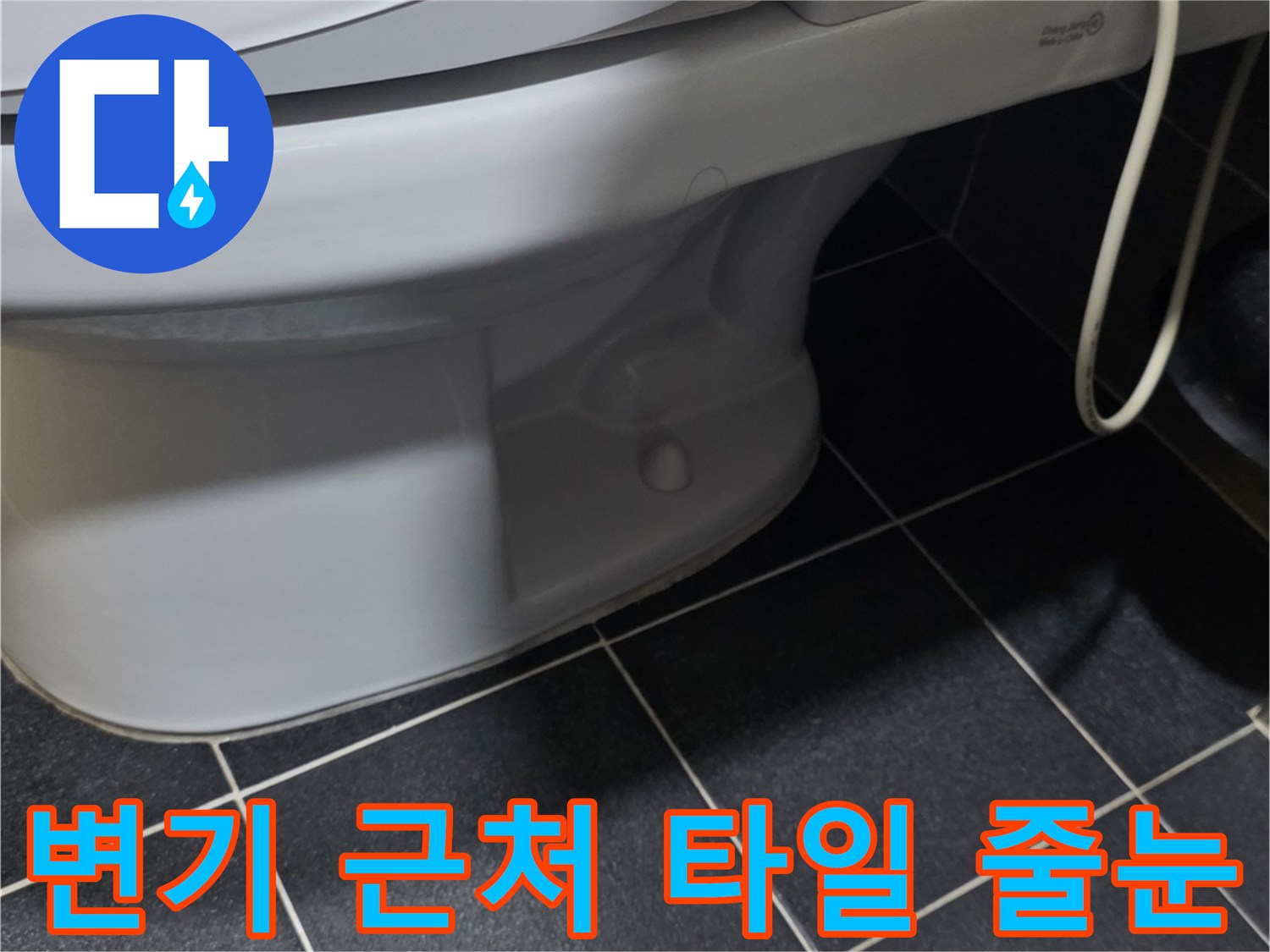 어두운 색의 화장실 타일과 변기 하단 경계 부위