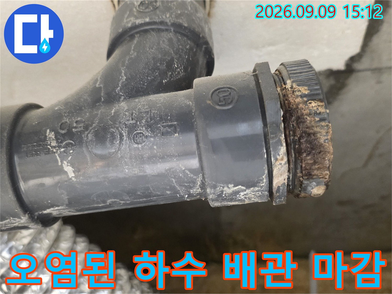 이물질로 인해 부식되고 오염된 하수 배연 연결부의 상세 모습입니다.