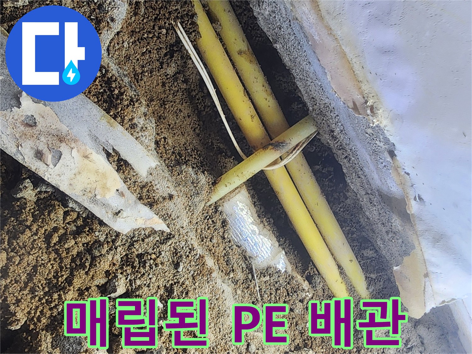 흙과 자갈 사이에서 발견된 손상된 노란색 PE 배관