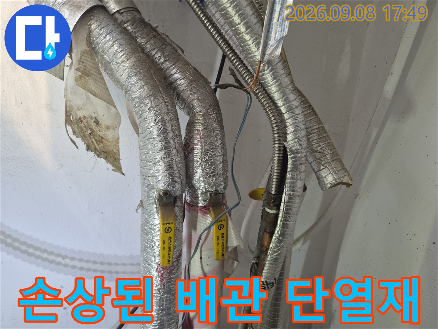 찢어진 은박 단열재와 내부 배관 연결 부위입니다.