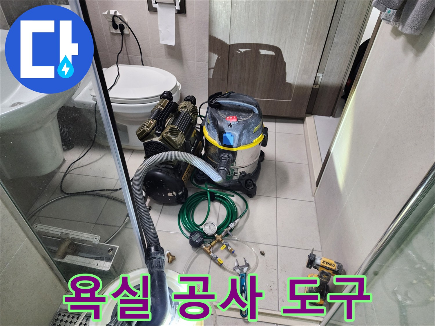 화장실 바닥에 준비된 배관 수리용 전동 도구와 청소 장비