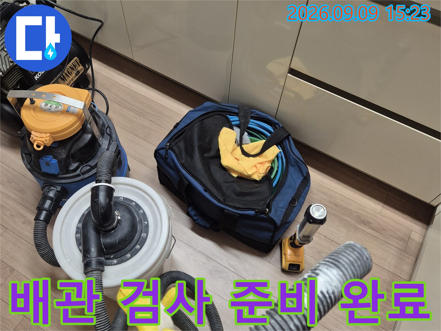 싱크대 아래 공간에 배치된 누수 진단용 전문 장비와 도구들입니다.