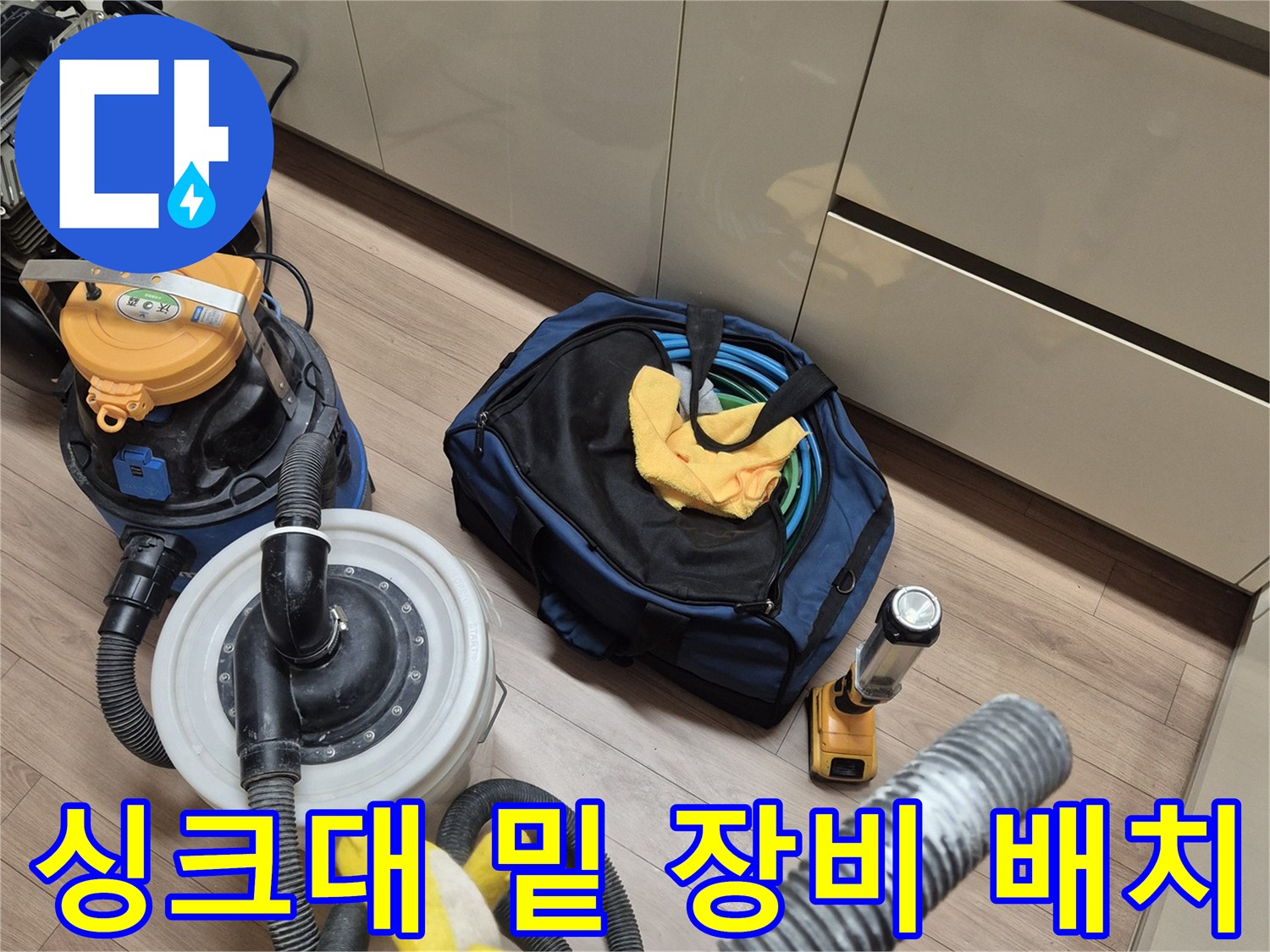 작업을 위해 싱크대 밑 공간에 놓인 청소기와 압력 측정기