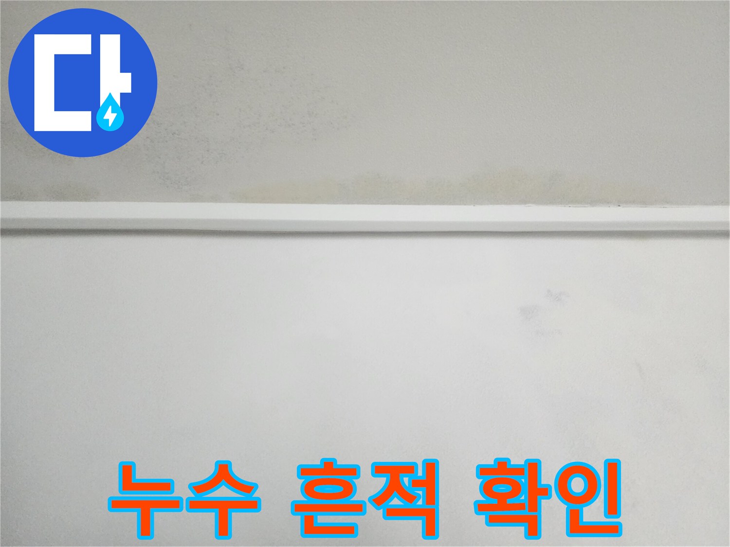 하얀 벽면 상단에 나타난 누수로 인한 변색 부위