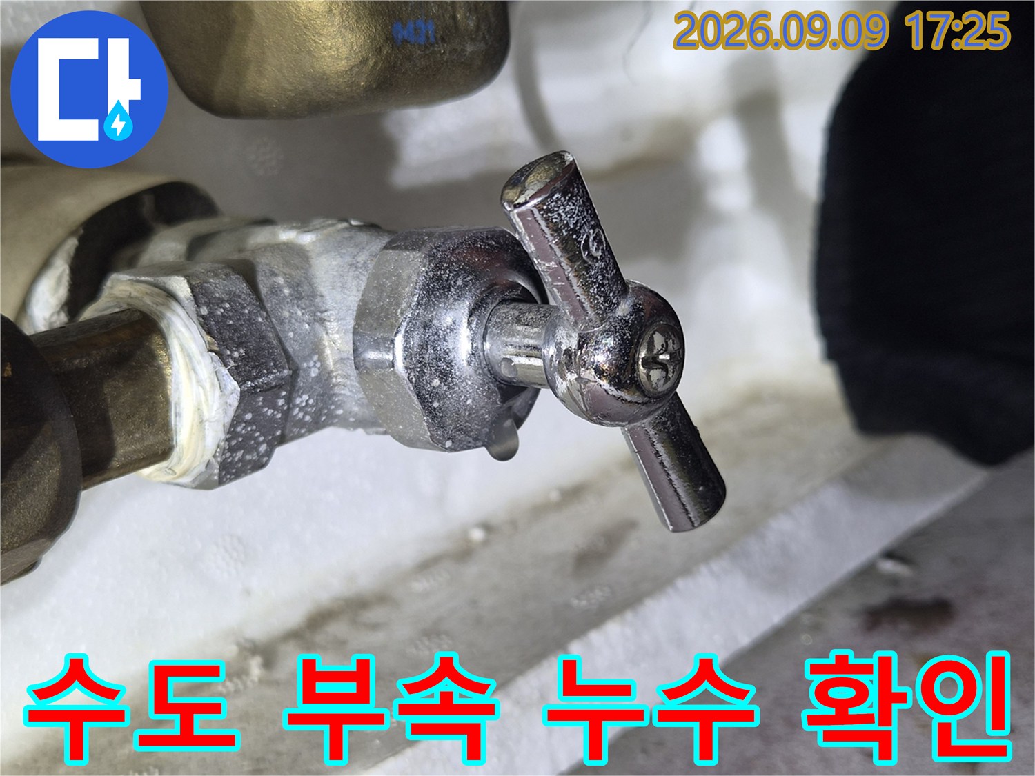 금속 소재의 수도 밸브와 연결된 배관의 상태를 보여주는 사진입니다.