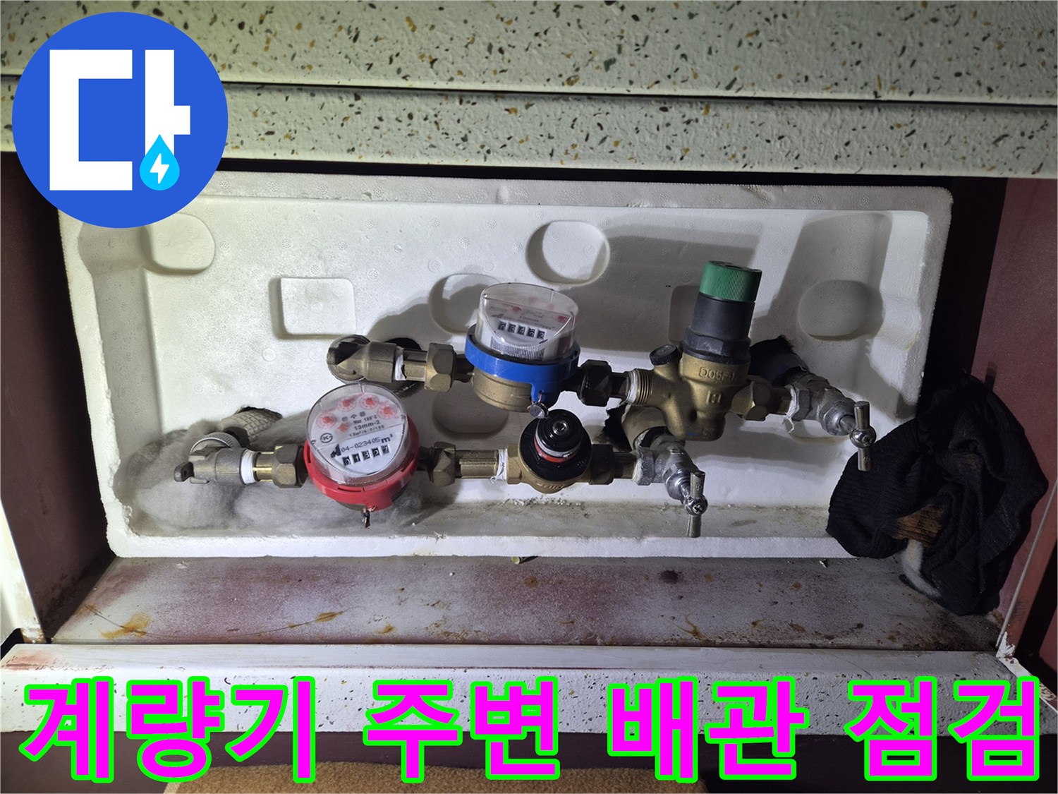 수도 계량기와 연결된 밸브 및 분기 배관의 정면 사진