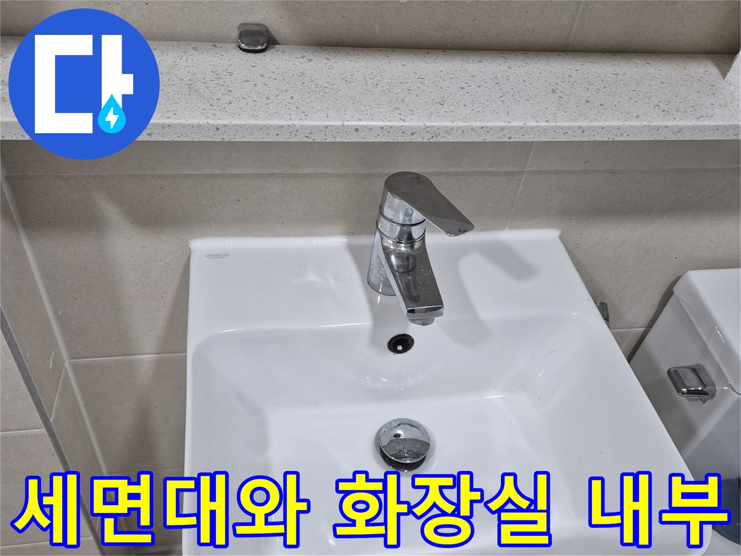 하얀색 세면대-옆에 위치한 수도꼭지와 타일 벽면