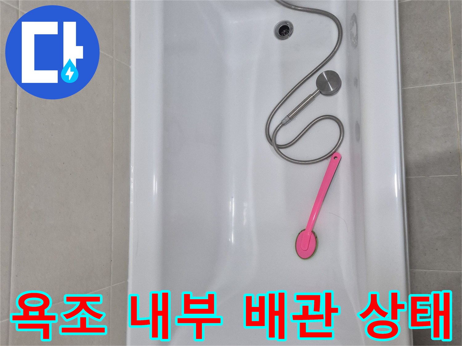 화장실 욕조 내부의 샤워기 호스와 배수구 주변 모습입니다.