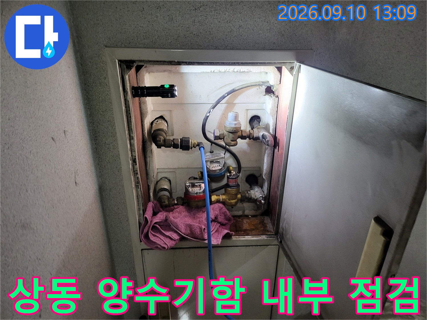 부천 상동 주택의 양수기함 내부에 설치된 수도 계량기와 연결 배관 상태를 확인하는 모습입니다.