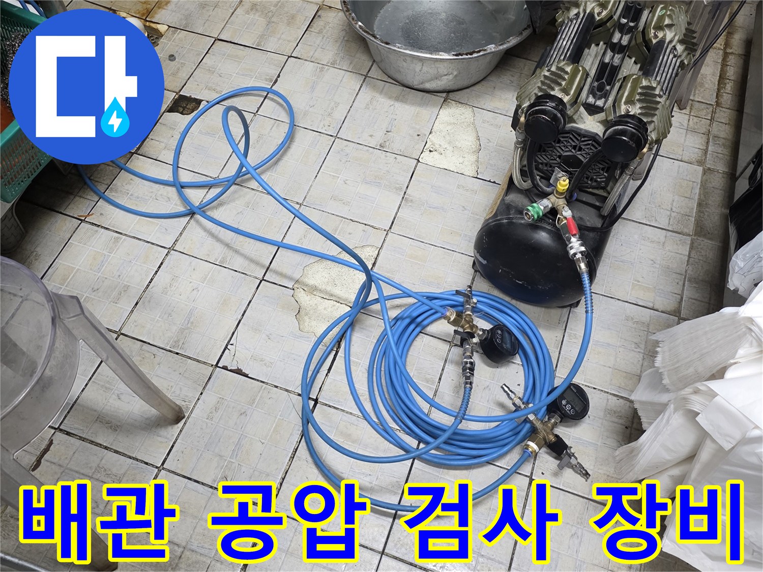 바닥 타일 위에 배치된 압력계와 연결 호스 및 가스 탱크
