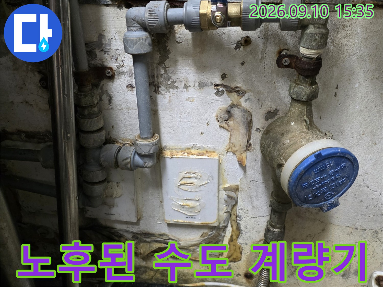 파란색 밸브와 계량기가 연결된 노후된 배관의 모습입니다.