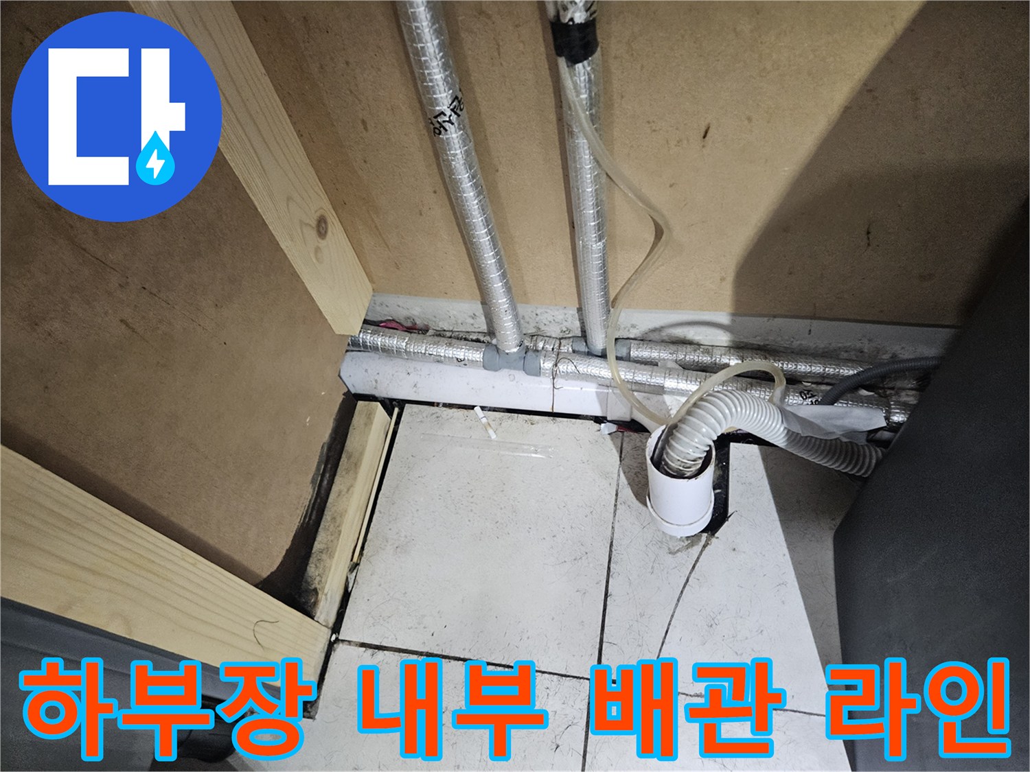 세면대 밑부분의 은색 보온재 배관과 흰색 플라스틱 호스 연결 부위입니다.