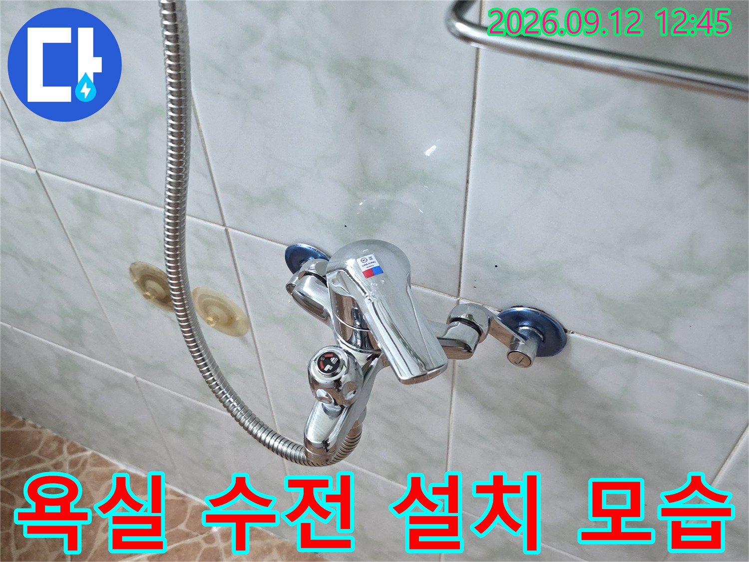 깨끗한 타일 벽면에 설치된 샤워 수전과 호스의 클로즈업 사진