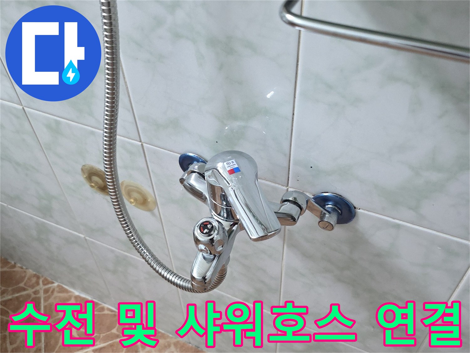 욕실 벽면에 설치된 수전과 금속 재질의 샤워 호스 클로즈업