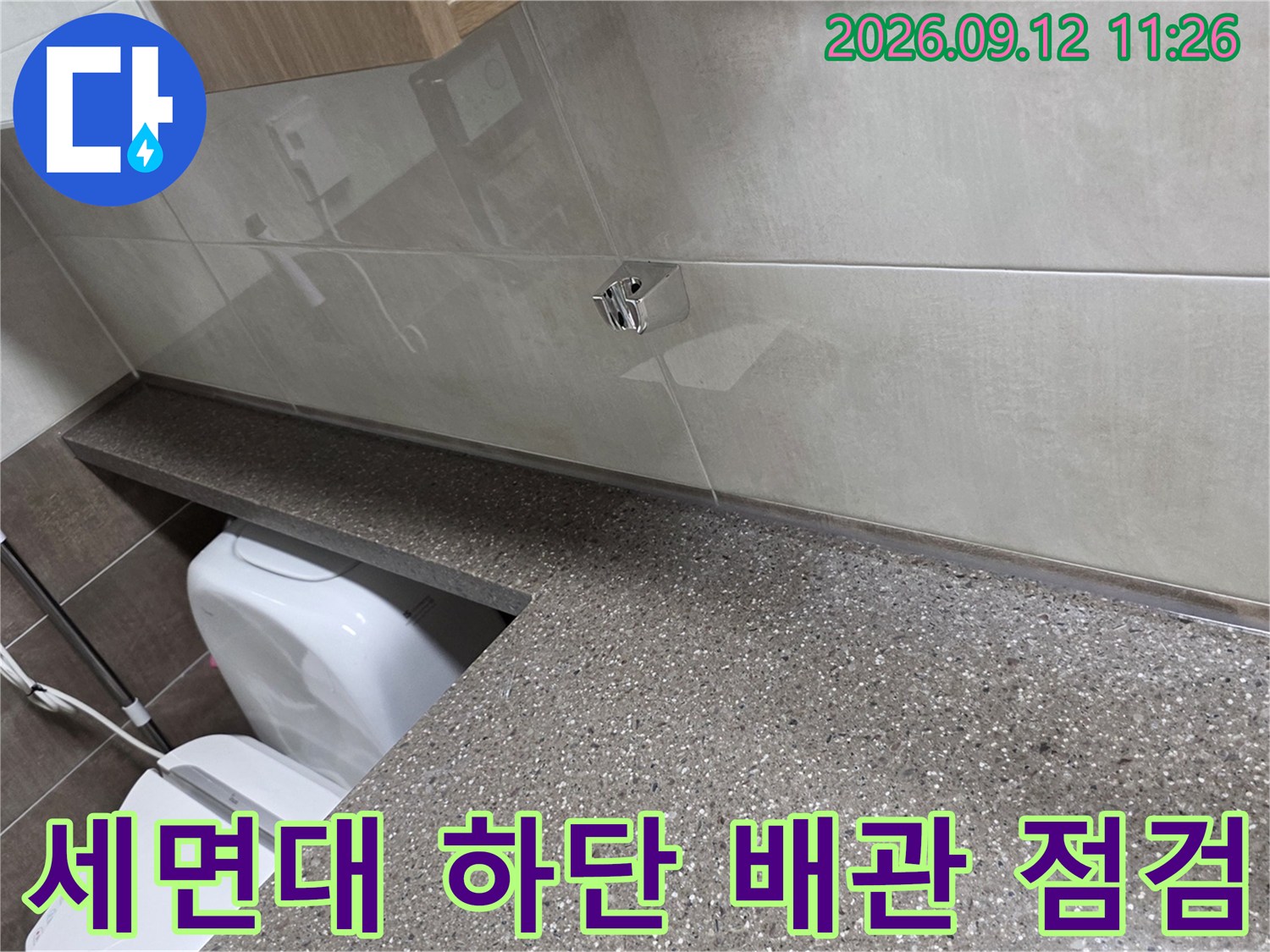 화장실 세면대 상판-타일 벽면과 연결된 배관 부위 모습