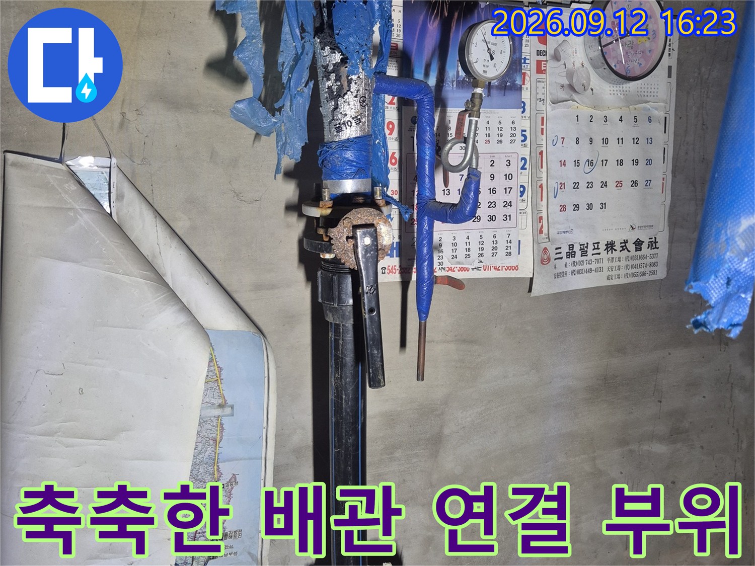 보온재가 씌워진 급수 배관과 수도 계량기가 설치된 지하 현장입니다.