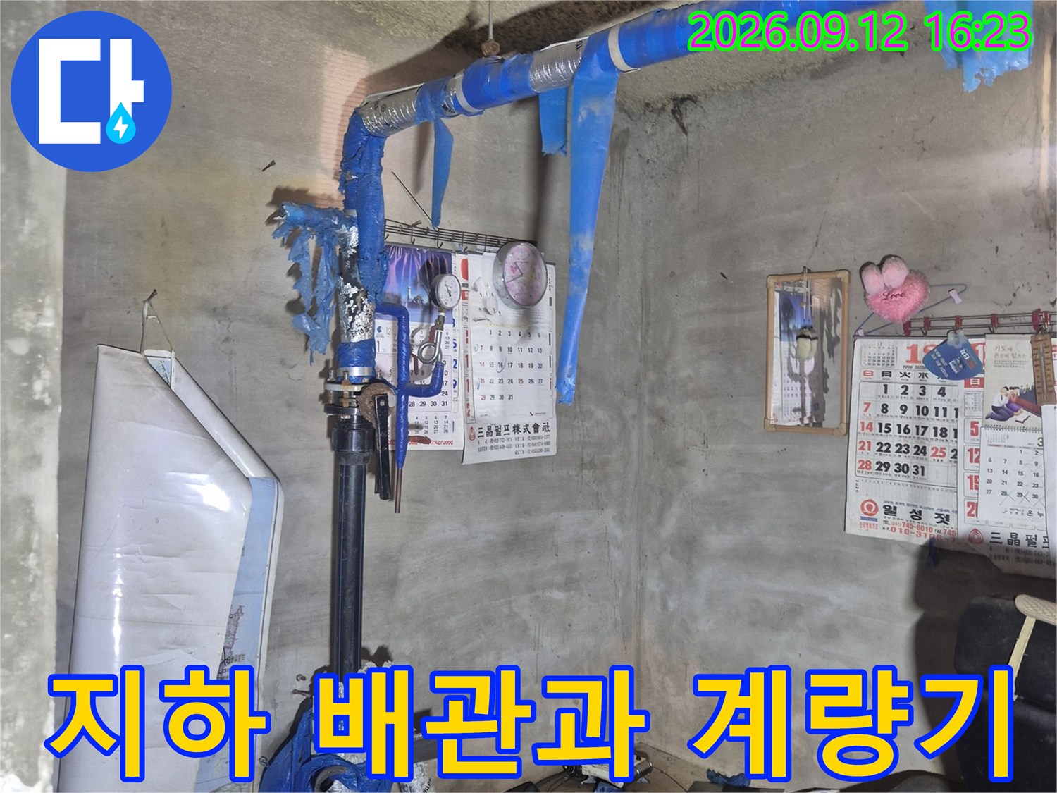 파란색 보온재가 입혀진 지하 급수 배관과 계량기 모습입니다.