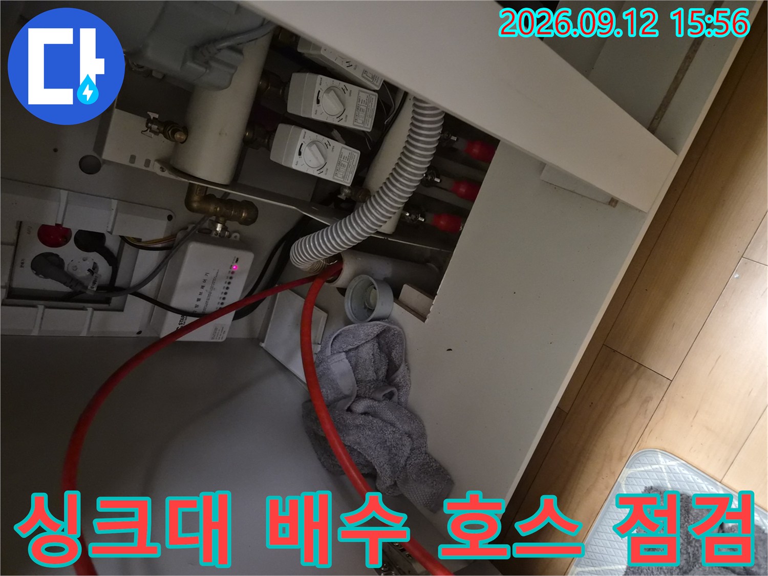 싱크대 하단 급수 밸브와 흰색 주름 배수 호스 사진